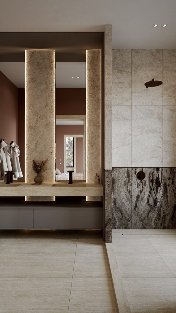 Baie modernă cu duș walk-in, finisaje din piatră naturală, lavoar suspendat și oglindă iluminată ambiental Amenajare realizată de Fabiano Interiors, expert design interior Oradea.