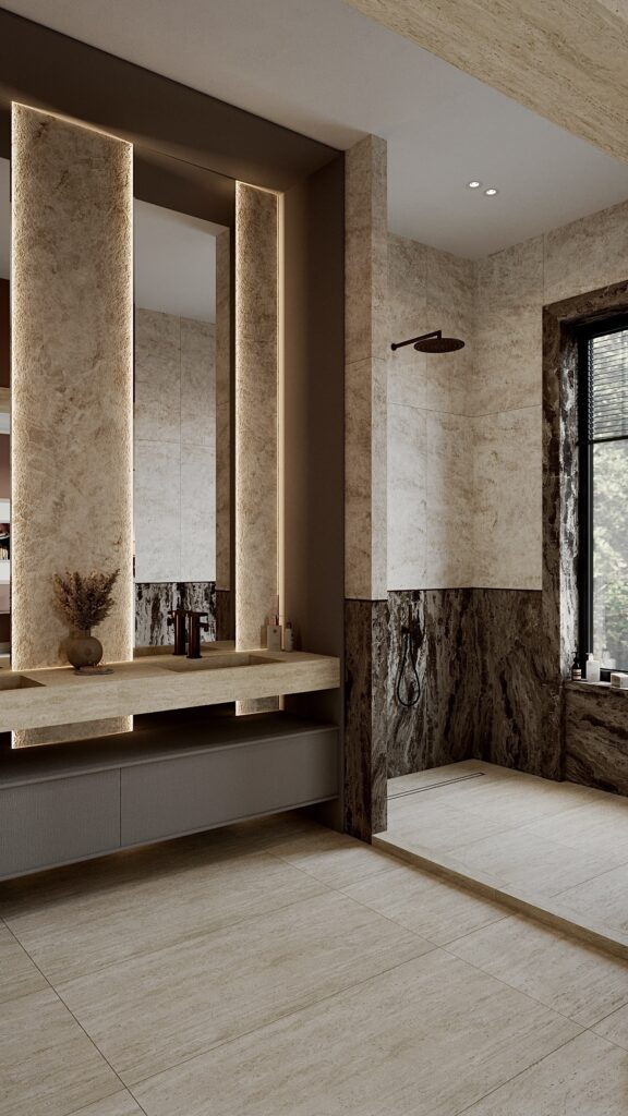 Baie modernă cu duș walk-in, finisaje din piatră naturală, lavoar suspendat și oglindă iluminată ambiental Amenajare realizată de Fabiano Interiors, expert design interior Oradea.