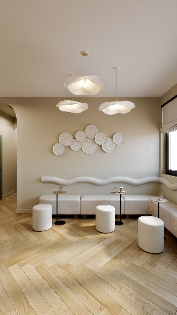 Proiect de design interior lounge în Oradea realizat de Fabiano Interiors, un spațiu de așteptare comercial rafinat ce include forme fluide pe perete, mobilier tapițat în nuanțe cremoase, zonă de cafea integrată discret, plante verzi decorative și o schemă cromatică senină inspirată din natura urbană.